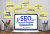 post-its and laptop showing various words related to SEO